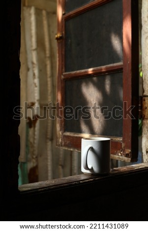 a cup of coffe in the middle of the window shoot in potrait angle