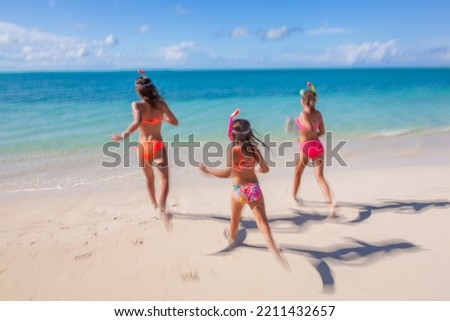 Young American Caucasian females in swimwear and snorkel equipment having fun by the beach on tropical island Caribbean resort 