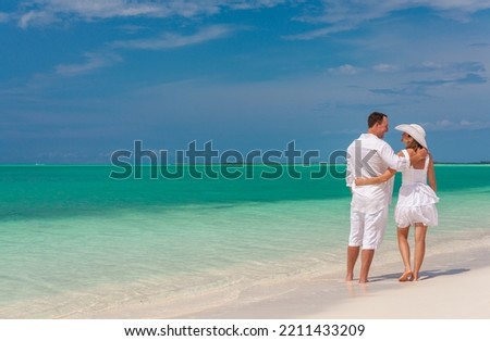 Healthy loving male and female Caucasian couple outdoors by the sea on Caribbean beach holiday paradise destination for travel