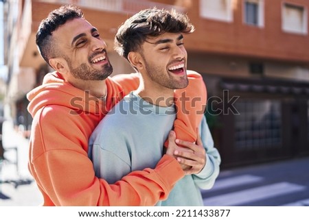 Two man couple hugging each other standing at street Royalty-Free Stock Photo #2211433877