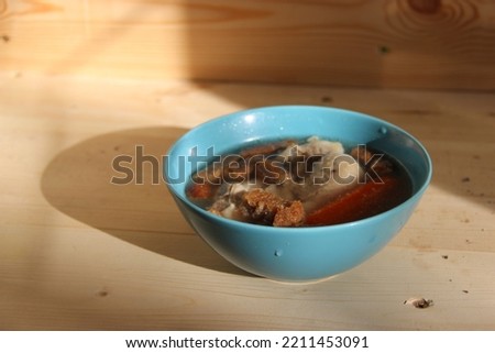 Chicken soup with carrots and croutons in a bowl.