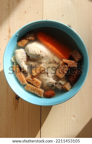 Chicken soup with carrots and croutons in a bowl.