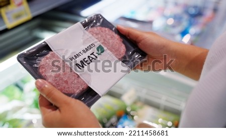 Close-up hand carry choose zero pork soy bean faux peas cutlet gluten free read beyond non-meat lab label. Buy raw fake beef tray in asia store veggie burger patty for health care eat diet meal cook. Royalty-Free Stock Photo #2211458681