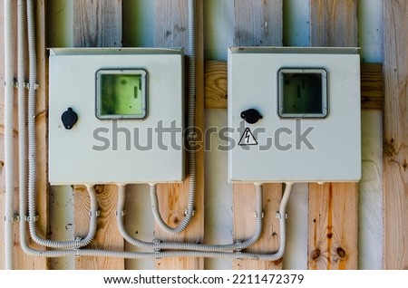 Accounting and distribution electrical panel with a high class of protection for outdoor use. safe electrical equipment. Electrical panels outside wooden house