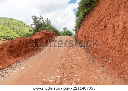 Rural mountain dirt uphill road view Royalty-Free Stock Photo #2211489353