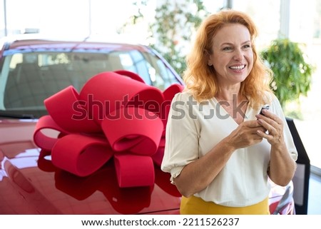 Beautiful woman holding the key to a new car in her hands