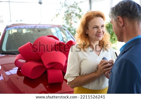 Woman takes the keys from a donated car from man