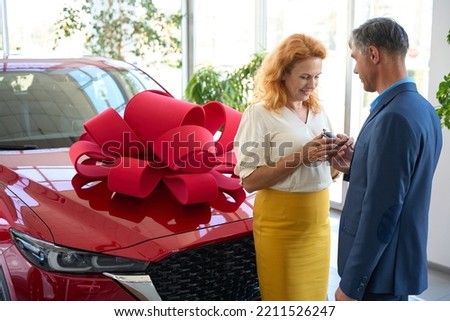 Husband giving his wife the keys to a new car