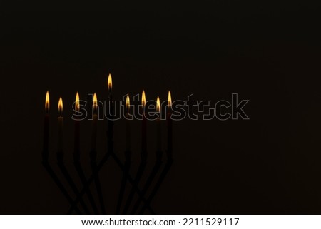In honor of Jewish holiday Hanukkah festival, symbols menorah are displayed black background with copy space Royalty-Free Stock Photo #2211529117
