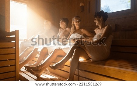 People in sauna relaxing and staying healthy. dramtic light with Steam, spa and wellness concept, relax in hot finnish sauna. Royalty-Free Stock Photo #2211531269