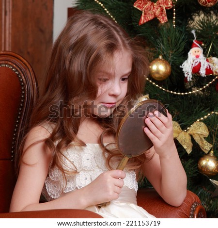 Picture of beautiful little princess girl with a mirror on Christmas time on Holiday theme 