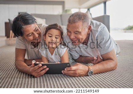 Relax, grandparents and cartoon on tablet with child on home floor together in the Philippines. Filipino family bonding time with grandfather, grandmother and grandchild watching animation online.