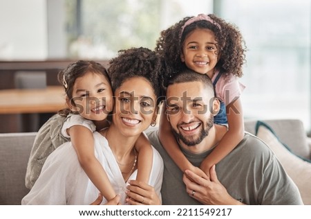 Happy, smile and portrait of an interracial family sitting on a sofa in the living room at home. Happiness, love and adoptive parents bonding, embracing and relaxing with their children in the lounge Royalty-Free Stock Photo #2211549217