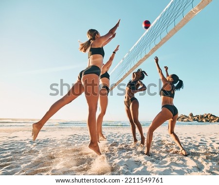 Beach volleyball, friends and women playing in the sand and summer sun. Fitness, diversity and sports on holiday in Brazil, woman team jumping for ball. Volley ball, bikini and a ball game at the sea Royalty-Free Stock Photo #2211549761
