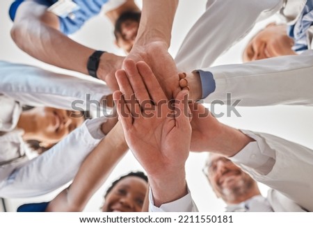 Hands, doctor and teamwork below in hospital for motivation, inspiration and diversity at work. Medical, team and hand together in collaboration at clinic, help community in healthcare and wellness Royalty-Free Stock Photo #2211550181