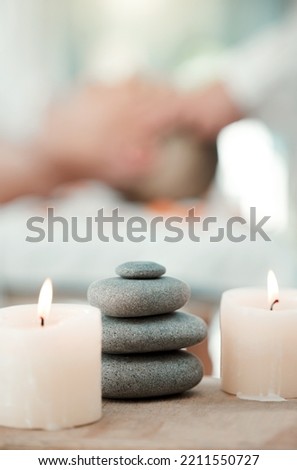 Spa, rock and candle to relax in a room with atmosphere, mood or ambience in a health club. Wellness, luxury and treatment with still life objects on a table in a clinic for rest and relaxation Royalty-Free Stock Photo #2211550727