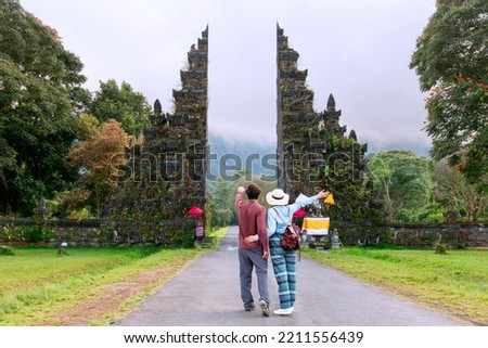Couple of travelers at Handara Gate in Bali - Indonesia - Two tourists exploring Bali landmarks