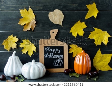 Autumn still life on a wooden background autumn leaves and berries, decorative pumpkins symbol of Halloween.  The concept of decorating houses, apartments on holidays.  Front view.