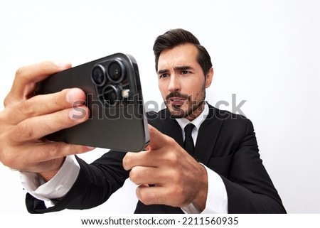 Man businessman holding the phone in his hand looking at him. Headache and anger from failure stress. Close-up wide angle photo white isolated background