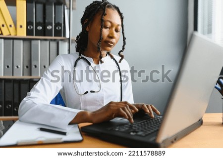 healthcare, medical and technology concept - african female doctor with laptop. Royalty-Free Stock Photo #2211578889