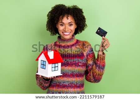 Photo of positive girl hold debit plastic card small house toothy smile isolated on green color background