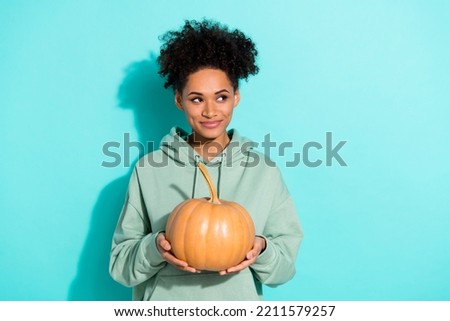 Photo of pretty minded lady hands hold pumpkin look empty space imagine isolated on vivid emerald color background