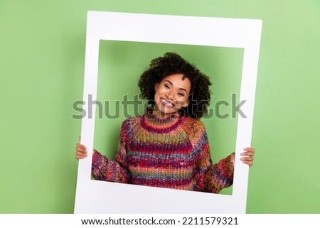 Portrait of cheerful pretty person hold paper album card have good mood isolated on green color background
