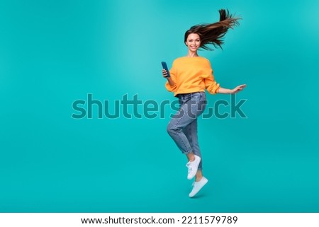 Full body size photo of young attractive pretty nice woman jump air walk go hold phone blogger popular internet isolated on cyan color background