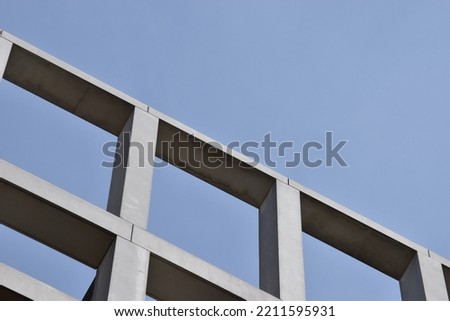 grey concrete architectural building frame against cool blue sky