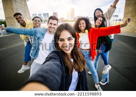 Multiracial young group of trendy people having fun together on vacation - Diverse millennial friends taking selfie portrait together while enjoying free time on city street - Friendship concept Royalty-Free Stock Photo #2211598893