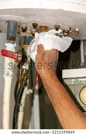 Solar boiler electrician. Solar water heater installer. Drains the boiler from the leak. with paper
 Royalty-Free Stock Photo #2211599869