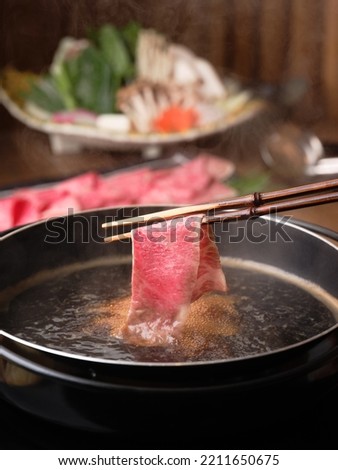 Japanese Wagyu A5 Shabu Shabu and Sukiyaki, vegetables set in the background, premium beef set, asian popular dish, japan local dish, chopsticks holding beef, fresh beef.  Royalty-Free Stock Photo #2211650675