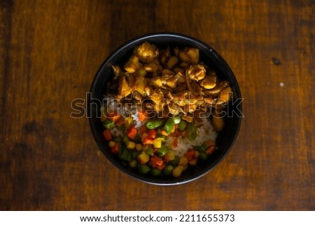 a bowl of chicken cut into small pieces served with rice and lalapannya. delicious!