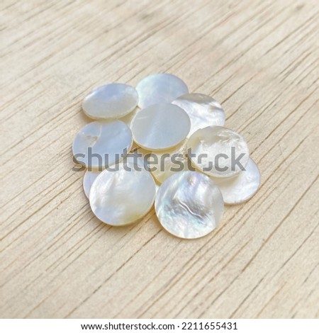 White Mother of Pearl Inlay, each shell is unique in color and texture with a shiny and iridescent finish, making it an ideal decorative material, especially as an inlay in rosewood furniture, guitar Royalty-Free Stock Photo #2211655431