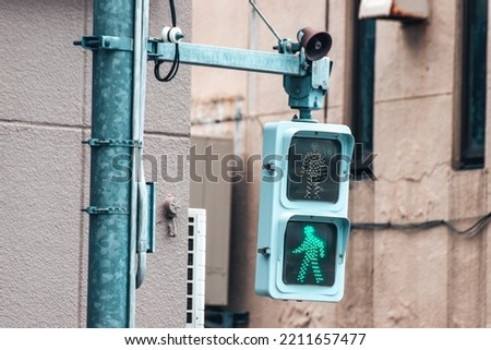 Close up of green Japanese pedestrian traffic light to warn pedestrian that it's not safe to cross the street. Royalty-Free Stock Photo #2211657477