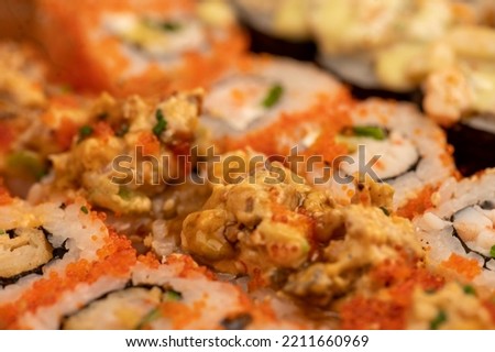 A set of different types of rolls in a box. Top view of various portions of vegetarian and fish rolls. Close-up, selective focus.