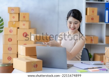 sme business idea cute asian woman selling online at home with laptop to take orders and to deliver yellow parcel boxes online delivery ideas
