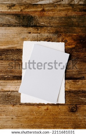 Two papers or invitation card  on an old wooden plank background