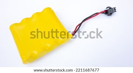 Yellow rechargeable battery on a white isolate. Sale of compact rechargeable batteries. Disposal of old batteries.