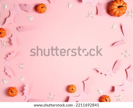 Halloween pink background with bats, spiders and pumpkins. Flat lay, top view frame with copy space.