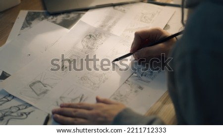 Animator creates sketches for the cartoon. Works on the storyboard. Comics Compilation. Storyboard movie layout for pre-production. Creative art work. Home based set up. Royalty-Free Stock Photo #2211712333