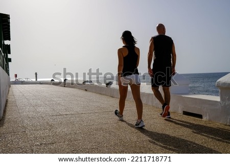 Couple walking along the sea doing sport