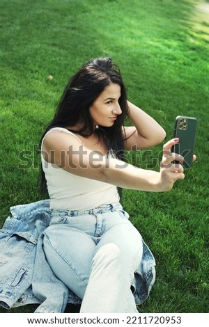Beautiful young woman outdoor portrait, young woman resting in city park and take a selfie photo