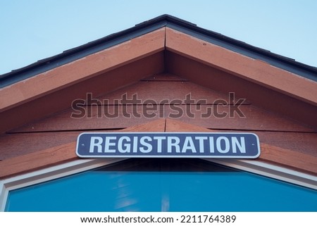 Registration sign above a wooden building