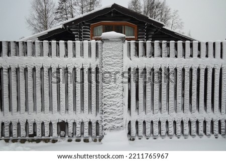 Severe frost. Wooden house with a fence. A lot of snow. High quality photo