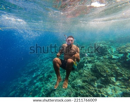 snorkeling young man with mask and snorkel underwater in the sea with clear water. High quality photo