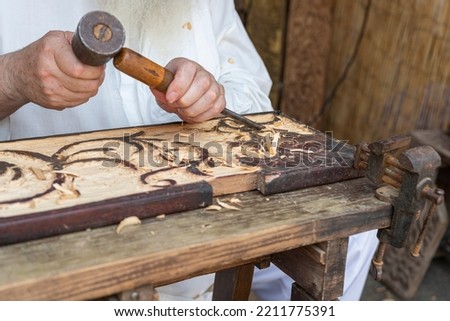 
meek old man carving wood