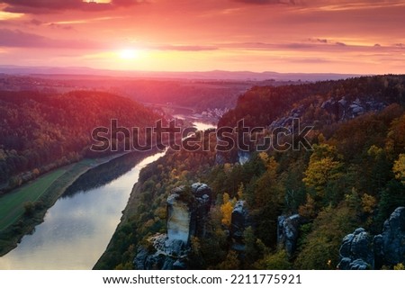 A wonderful sunset over the river Elbe that breaks through the mountain range in a steep and narrow valley. Saxon Switzerland National Park. Germany. Saxony. Royalty-Free Stock Photo #2211775921