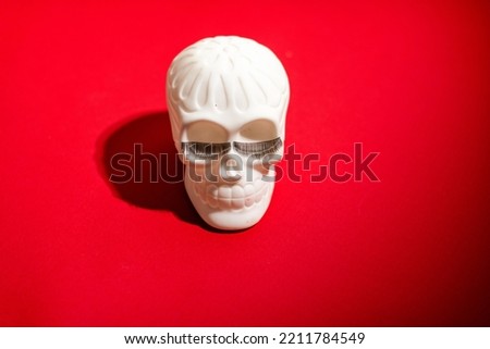Cheerful Human skull with eyelashes on a red background. Halloween decorations. Halloween concept. Flat lay, top view, copy space. 