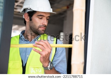 Mechanical Engineer working with use tape measure on construction home building site 